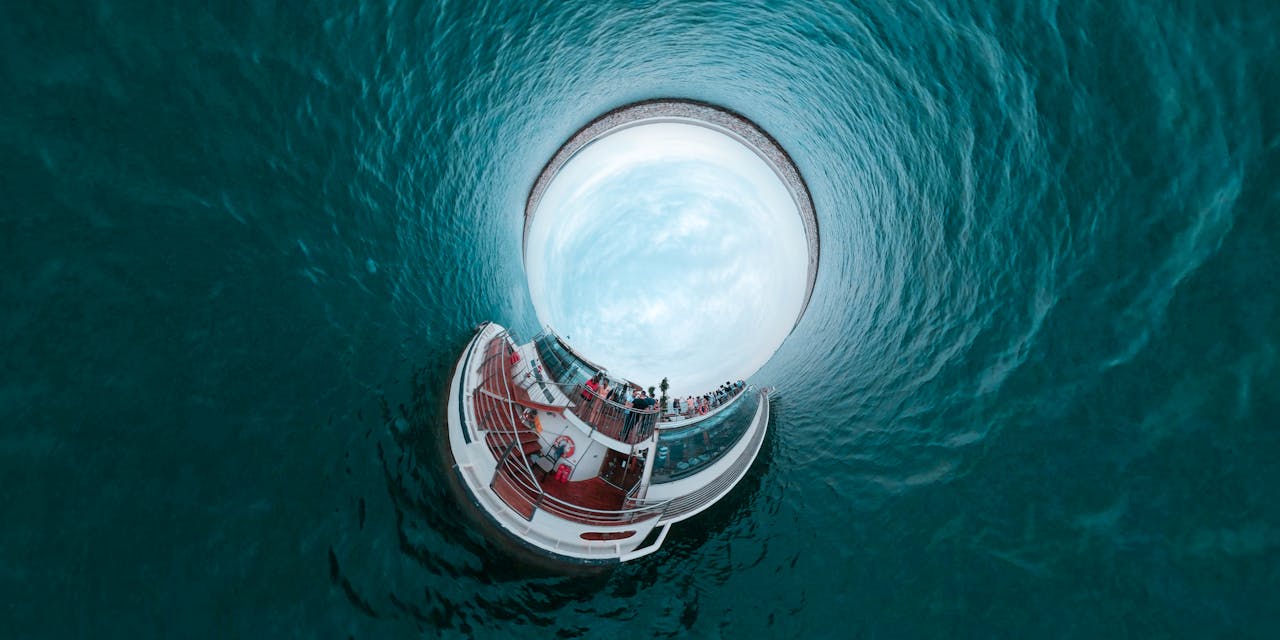 A stunning tiny planet effect image featuring a cruise ship surrounded by ocean water, capturing a unique perspective.