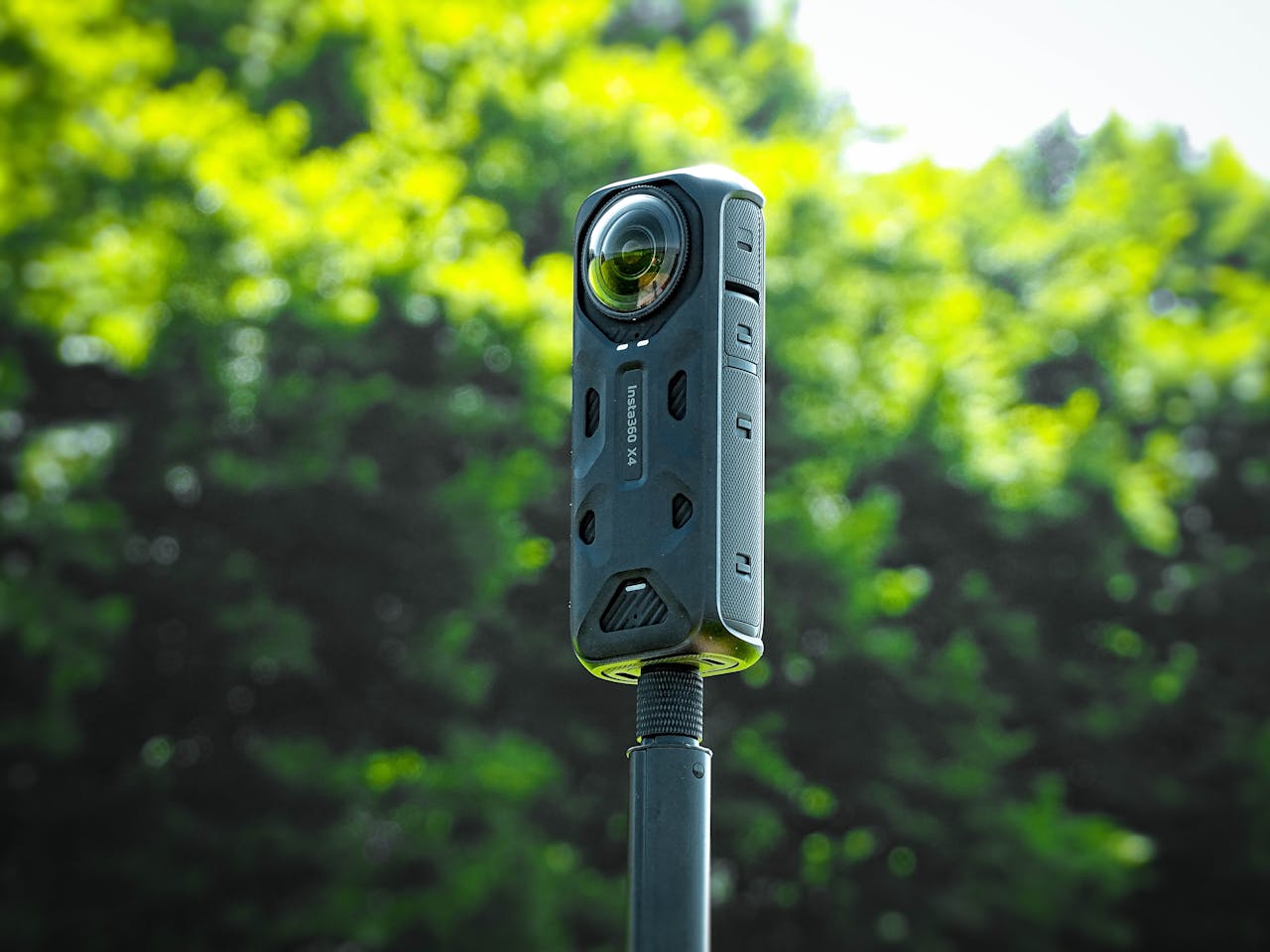 Close-up of a rugged action camera mounted on a tripod outdoors, showcasing its modern design and technology.